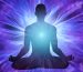 Silhouette of man in meditation and surrounded by rays of light and energy
